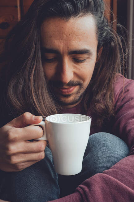 Bearded man resting with hot beverage — Stock Photo