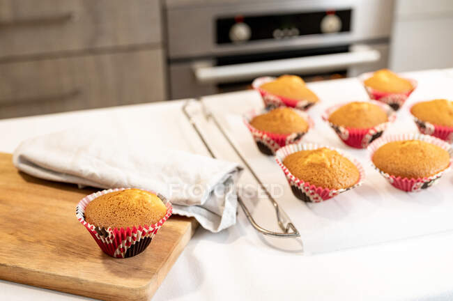 Cupcake appena sfornati su una moderna superficie del controsoffitto della cucina a casa — Foto stock