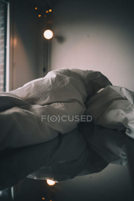 Miroir sur un lit dans une chambre sombre à la maison — Photo de stock
