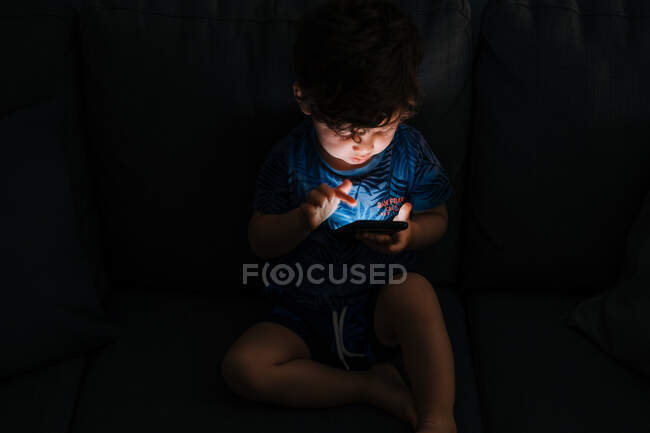 Curioso smartphone di navigazione bambino a casa — Foto stock