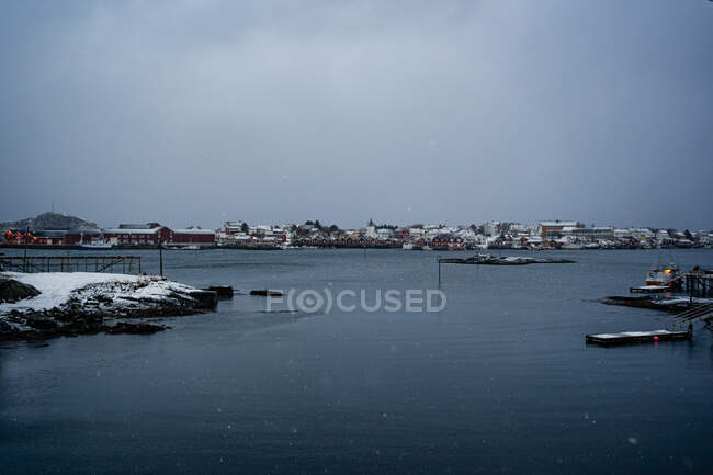 D'en haut du port de la ville contre des crêtes de montagne enneigées à l'horizon par temps couvert en Norvège — Photo de stock