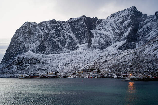 Dall'alto del porto della città contro creste di montagna innevate all'orizzonte in tempo coperto in Norvegia — Foto stock