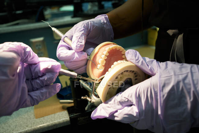 Colegas pretas examinando prótese em laboratório — Fotografia de Stock