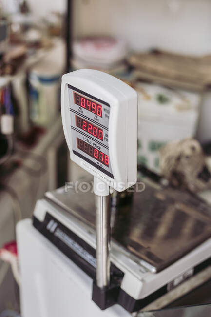 Выше взвешивающая машина с электронным дисплеем, размещенным на прилавке в местном продовольственном магазине — стоковое фото
