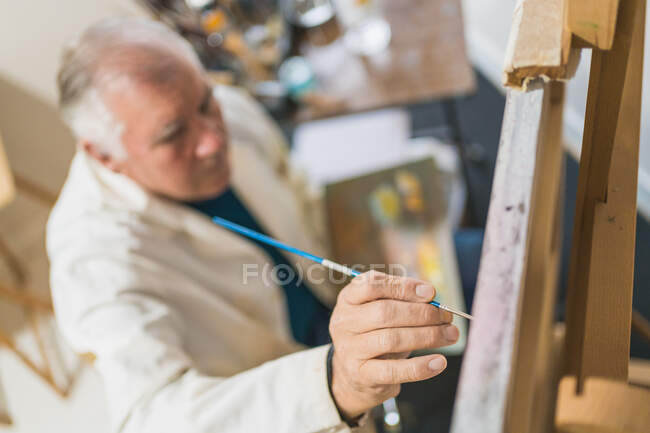Homme âgé peinture tableau avec pinceau — Photo de stock