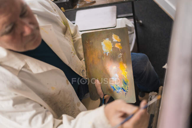 Homme âgé peinture tableau avec pinceau — Photo de stock