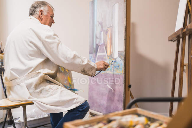 Картина пожилого человека с кистью — стоковое фото