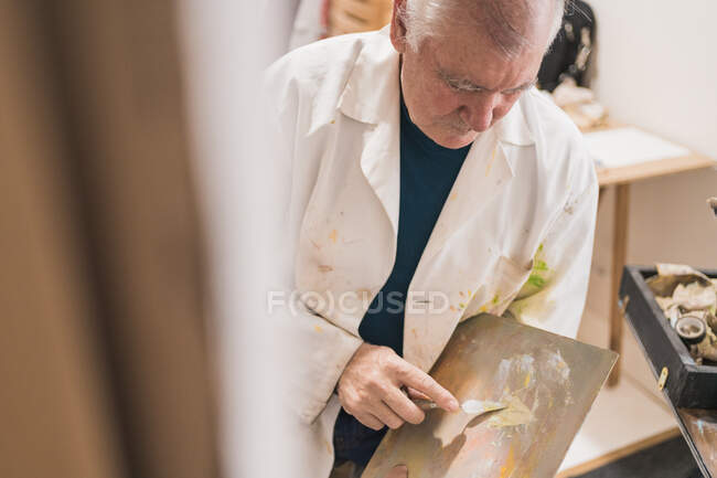 Картина пожилого человека с кистью — стоковое фото
