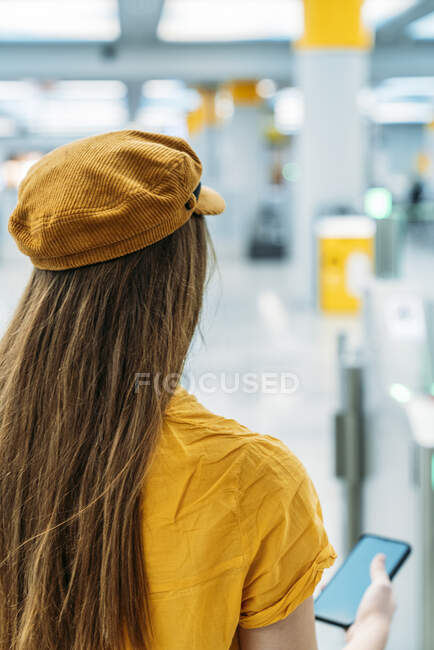 Pasajera en traje de moda de pie junto al mostrador en el aeropuerto - foto de stock