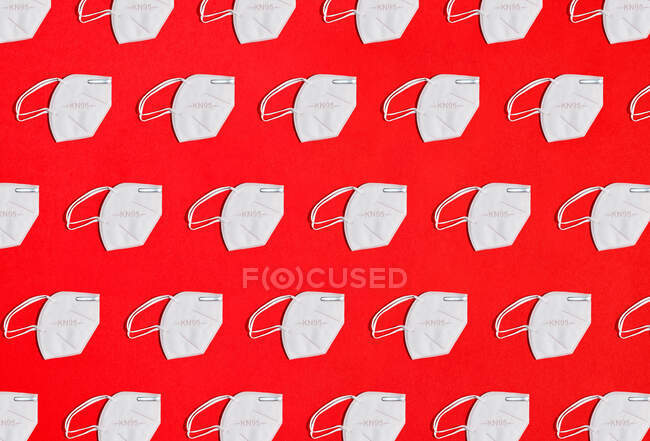 Colagem de muitas máscaras de proteção de fator KN95 em uma visão aérea de fundo vermelho — Fotografia de Stock