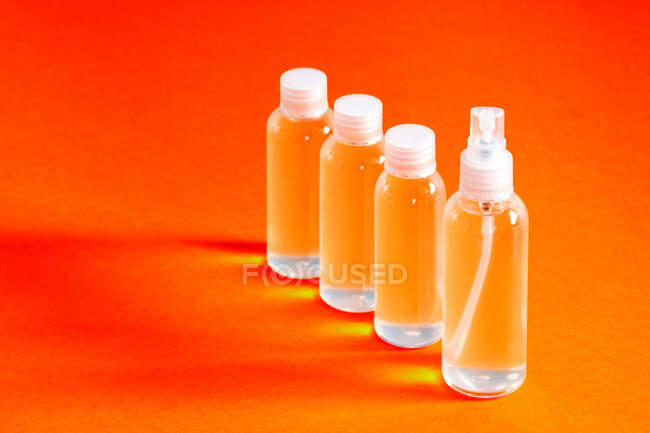 Varios frascos transparentes con gel clorhídrico junto con un embudo para llenar sirve para desinfectar las manos de covid-19 vista superior - foto de stock