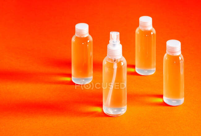 Vista dall'alto disallineato di varie bottiglie trasparenti con gel cloridrico per il riempimento serve a disinfettare le mani di covid-19 — Foto stock