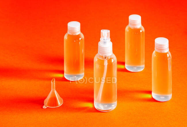 Vista superior desalineada de varias botellas transparentes con gel clorhídrico para el llenado sirve para desinfectar las manos de covid-19 - foto de stock