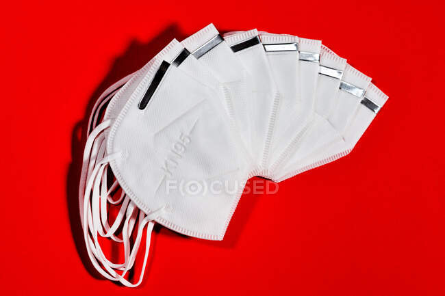 Grupo de máscaras brancas ventilado com índice de proteção KN95 reutilizável para proteção contra vírus em fundo vermelho — Fotografia de Stock
