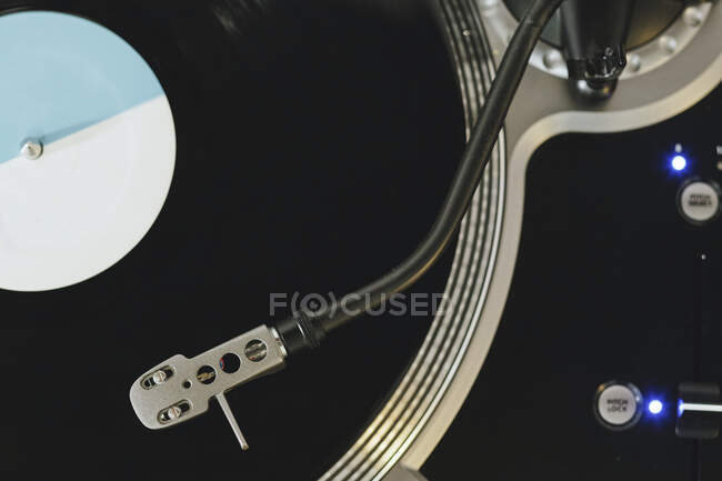 From above close up of contemporary vinyl record player with retro disc placed on wooden table in living room — Stock Photo