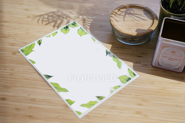 Vista superior de papel laminado menu composto em mesa de madeira perto vaso de flores e vários itens de madeira e metal — Fotografia de Stock