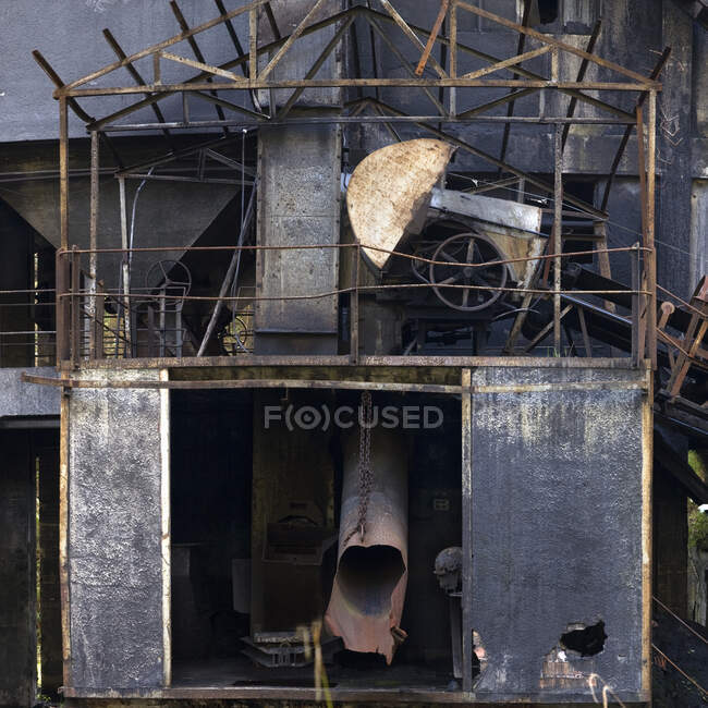 Shabby metal estrutura de dois níveis coberta com camada de ferrugem com tubos em ruínas e barras curvas de grades em mina de carvão abandonada — Fotografia de Stock