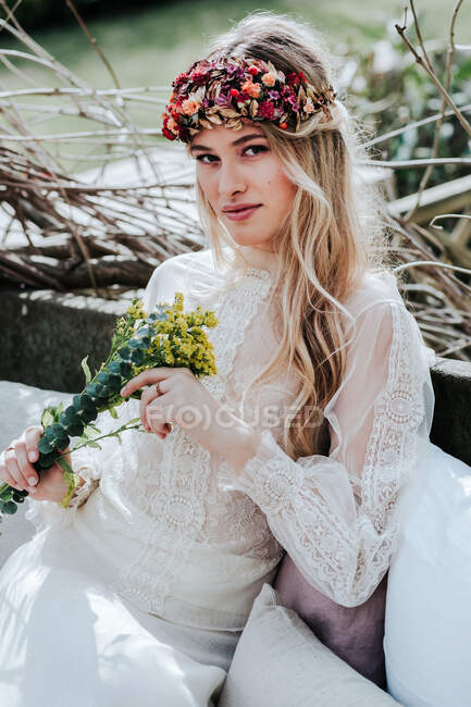 Young bride with wreath and flowers — Stock Photo