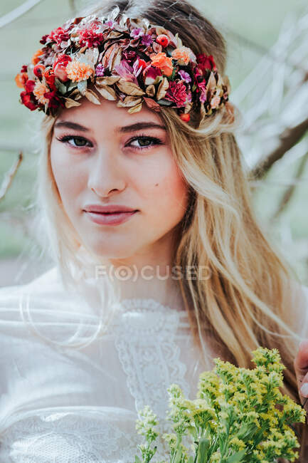 Giovane sposa con corona e fiori — Foto stock