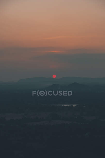 D'en haut de vue majestueuse sur le soleil et les silhouettes des sommets de montagne pendant le coucher du soleil à Sigiriya — Photo de stock