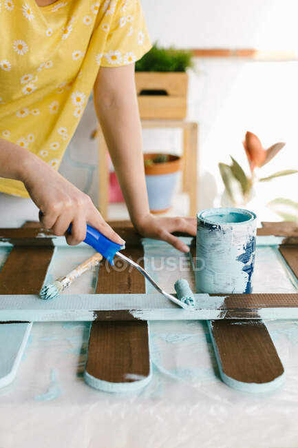 Close-up view of one person painting and restoring an old fence. — Stock Photo