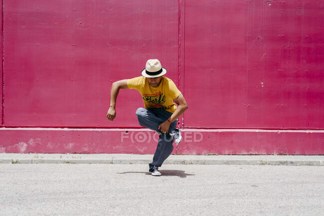 Jóvenes hispanos bailando cerca de una pared rosa en la calle - foto de stock