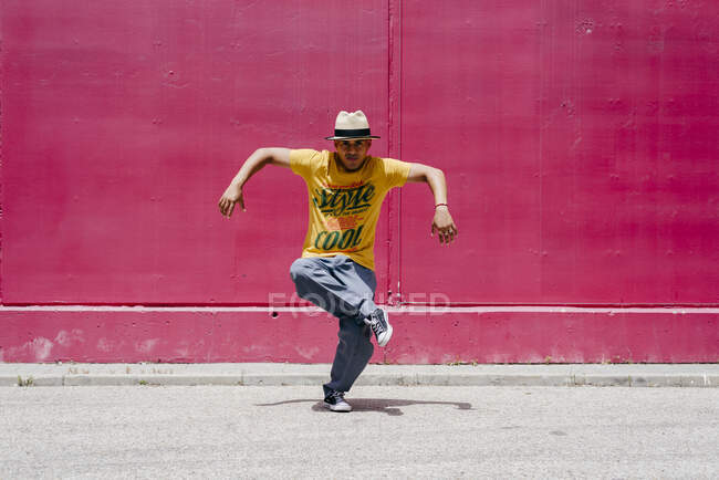 Giovani uomini ispanici che ballano vicino a un muro rosa per strada — Foto stock