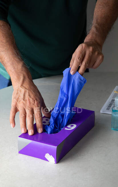 Mains masculines prenant des gants en latex de la boîte — Photo de stock