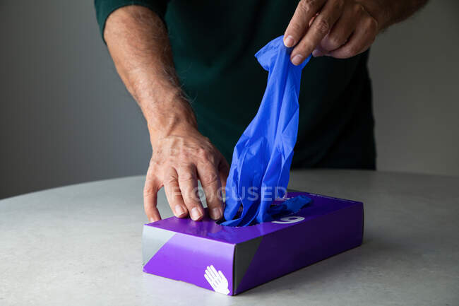 Mains masculines prenant des gants en latex de la boîte — Photo de stock