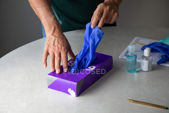Mani maschili che prendono guanti di lattice dalla scatola — Foto stock