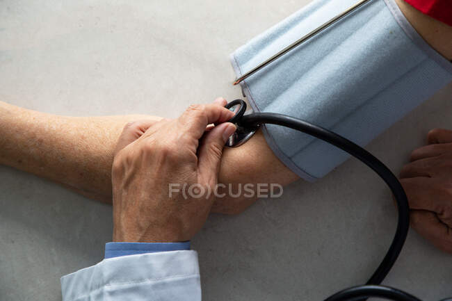 Plan recadré du médecin en utilisant stéthoscope sur la main du patient — Photo de stock