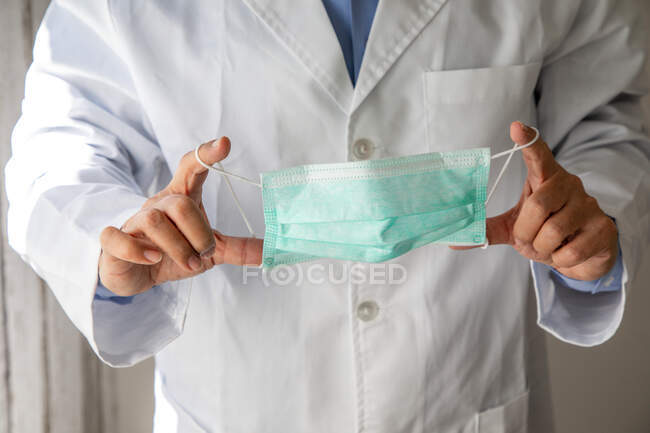 Male doctor hands holding medical mask ready to wear — Stock Photo