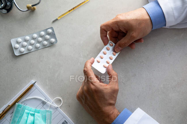 Homme médecin mains tenant paquet de pilules — Photo de stock