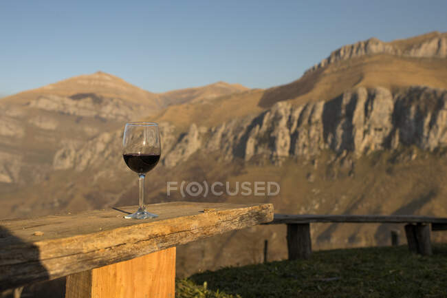 Verre de vin rouge avec montagnes et ciel bleu sur le fond, Cantabrie — Photo de stock