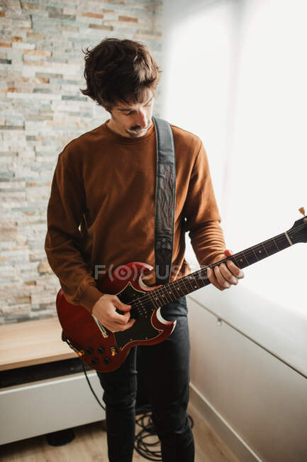 Homem tocando guitarra em casa — Fotografia de Stock