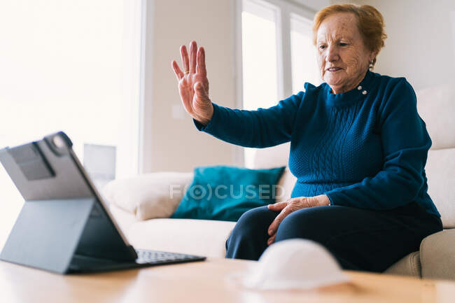 Старша жінка спілкується з другом під час відеочату на ноутбуці — стокове фото
