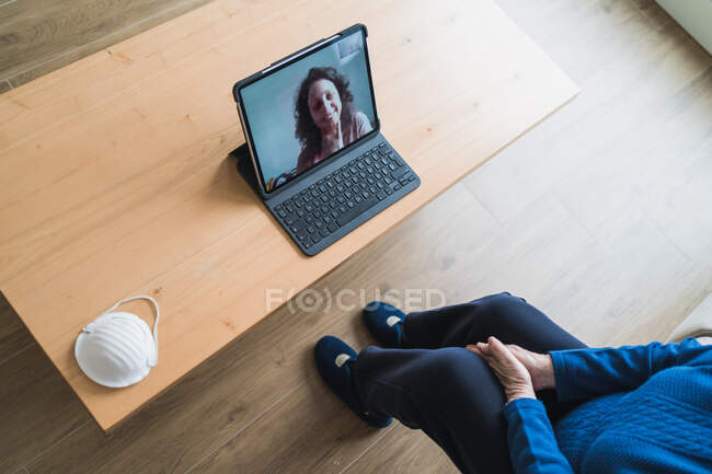 Старенька жінка спілкується з дочкою під час відеобесіди на ноутбуку. — стокове фото