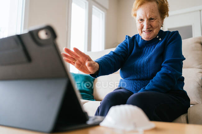 Mujer mayor comunicarse con un amigo durante el chat de vídeo en el ordenador portátil - foto de stock