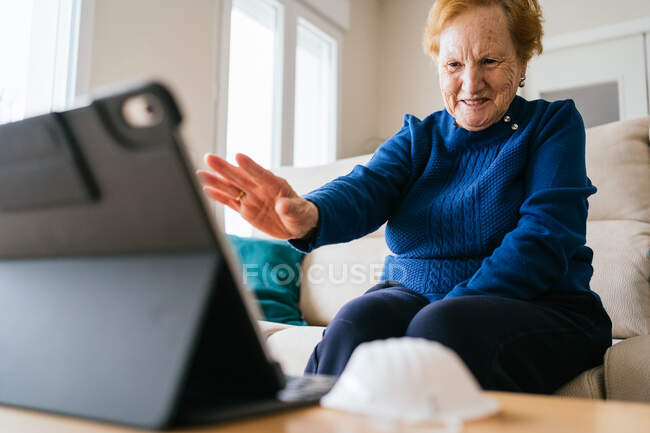 Senior woman communicating with friend during video chat on laptop — Stock Photo