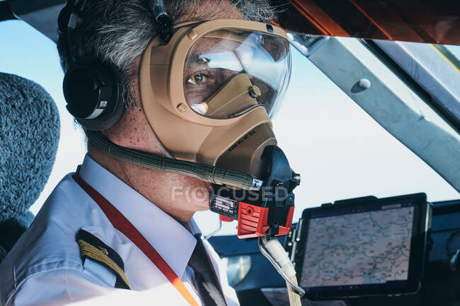 Piloto em máscara operando avião durante o voo — Fotografia de Stock