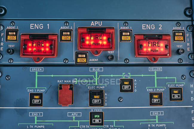 Крупный план пожарных кнопок и предупредительных огней на пульте управления в кабине современного самолета — стоковое фото