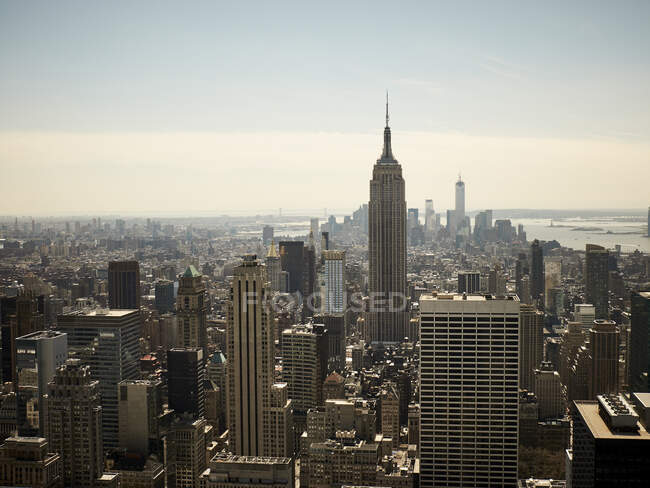 Vista de la ciudad de Nueva York con rascacielos y Empire State Building en un día soleado - foto de stock