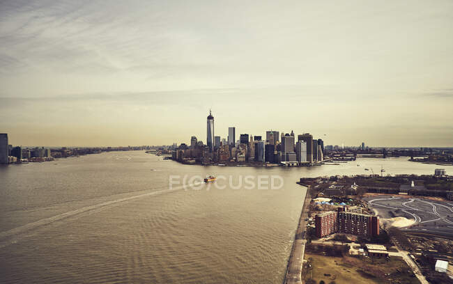 Vue aérienne de l'île de New York et des gratte-ciel de Manhattan avec de l'eau paisible dans le canal à la lumière du soleil — Photo de stock