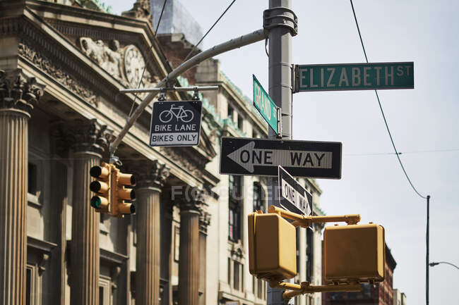 Dal basso di segnali stradali a senso unico all'incrocio con moderni edifici alti sullo sfondo a New York — Foto stock