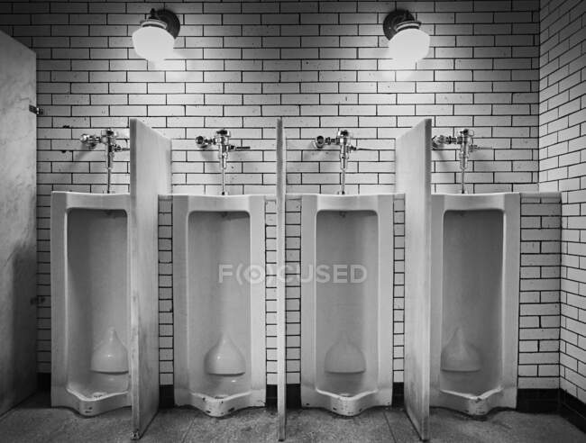Intérieur des toilettes publiques éclairées avec mur de briques dans le bâtiment public de New York — Photo de stock
