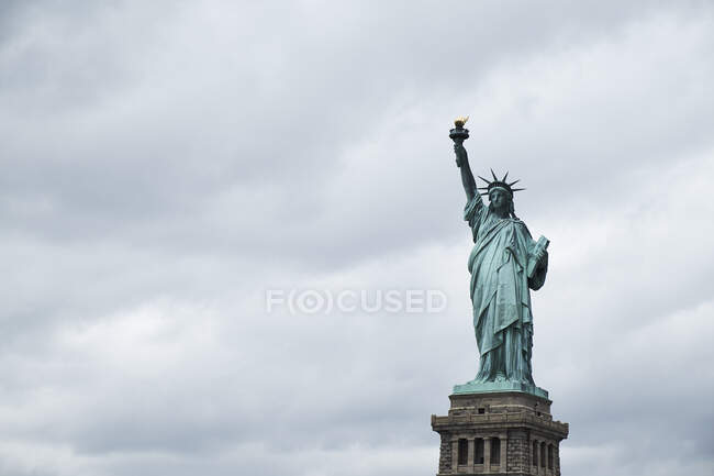 Estatua de la Libertad contra el cielo nublado - foto de stock