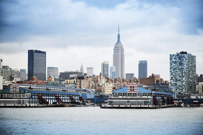 Сьогоднішні хмарочоси Нью - Йорка, видимі з ріки проти блакитного хмарного неба в сонячний день. — стокове фото