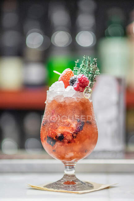 Berry cocktail with ice and fresh herbs at bar counter — Stock Photo