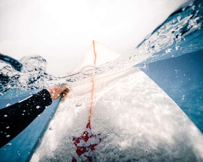 Unkenntliche Person auf Surfbrett versinkt während Fahrt nahe der Insel Fuerteventura in klarem Meerwasser — Stockfoto