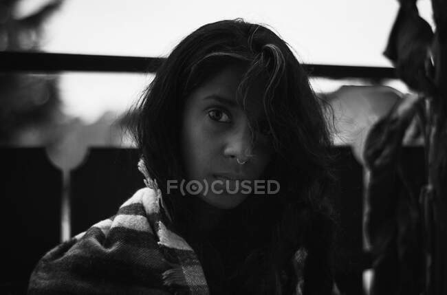 Молода етнічна жінка з пірсингом носа дивиться на камеру в традиційному одязі — стокове фото